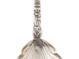 une cuillère en argent à long manche sur fond blanc