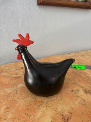 un poulet noir posé sur une table, à côté d'un couteau