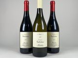three bottles of wine sitting on top of a white table