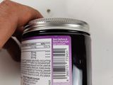 a hand holding a jar of hair product with a label on it