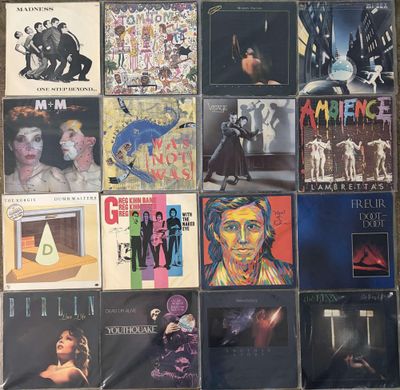 various album covers are arranged on a wall in a room