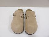 pair of beige sued clogs with buckles on each side