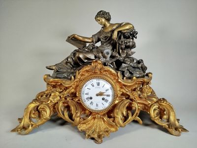 a gold clock with a statue on top of it