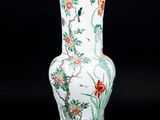 un vase blanc orné de fleurs rouges sur fond noir