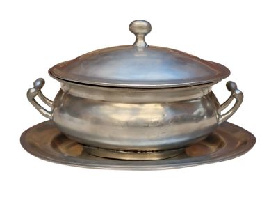 un plat en argent muni d'un couvercle en argent et posé sur une soucoupe en argent