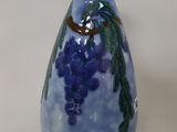 a blue vase with a bunch of grapes painted on it