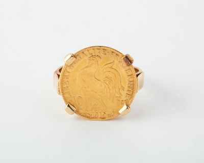 a close up of a gold coin ring on a white surface