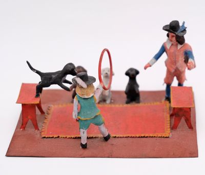 toy figurines of a boy playing with a dog and a tennis racket