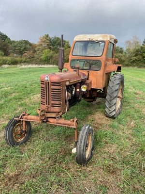 un vieux tracteur rouillé, abandonné dans un champ sous un ciel nuageux