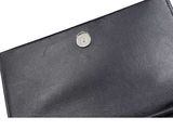 the black leather wallet has a metal button on the front