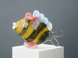 une figurine en verre représentant un poisson avec un nœud sur la tête