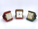 three different colored clocks sitting on top of a white table