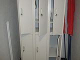 un placard dans un coin d'une pièce, avec une serviette rouge accrochée à la porte