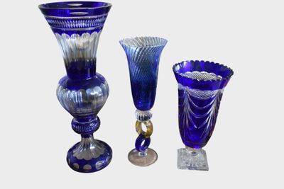 three blue glass vases sitting next to each other