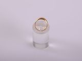 a white and gold ring sitting on top of a clear glass