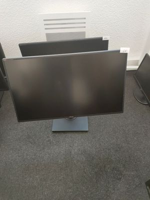 two monitors are sitting on the floor in front of a white wall