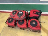several red and black lawn mowers sitting on top of a pile of hay