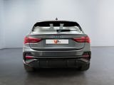 the rear end of a grey audi vehicle in a white room