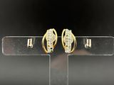 a pair of gold and diamond earrings on a stand