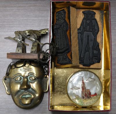 a gold box with a metal object and a bronze mask
