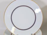 three white and gold plates stacked on top of each other