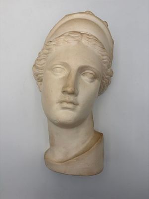 a close up of a sculpture of a woman ' s head on a wall