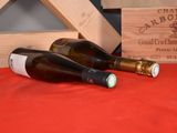 two bottles of wine sitting on a table next to a wooden crate