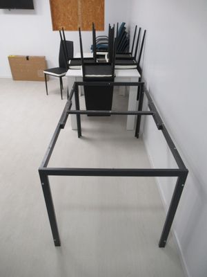 une table en verre avec des chaises au milieu de la pièce
