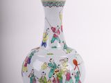 a white vase with a painting on it on a wooden stand