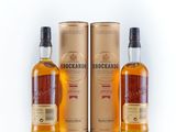 three bottles of whisky are sitting next to each other on a white surface