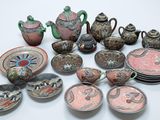many pieces of pottery sitting on a white surface