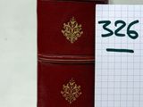 un livre rouge posé à côté d'un bloc-notes sur une table