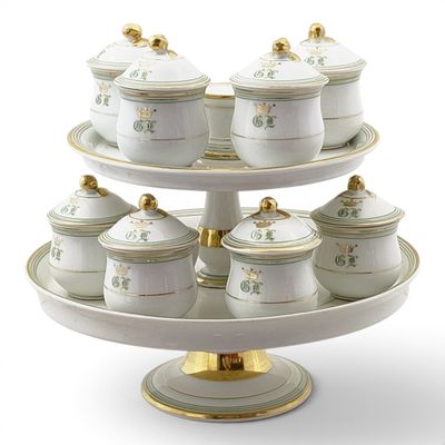 a cake stand with a lot of white and gold dishes on it