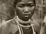 an old black and white photo of a woman with pearls on her neck