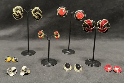 a lot of different earrings on display on a black table
