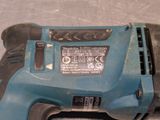 a blue drill with a black handle sitting on a table
