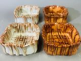 deux vases marron et blancs posés l'un à côté de l'autre sur une table