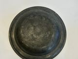 a close up of a metal bowl on a white surface