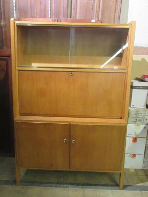 a wooden cabinet with a glass door in a room