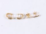 three pairs of gold earrings on a white surface