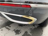 the rear end of a car with a dented bumper