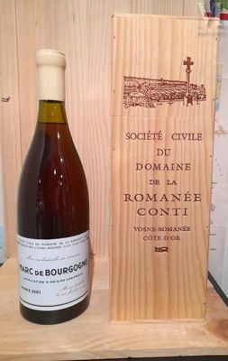 une bouteille de vin posée à côté d'une caisse en bois