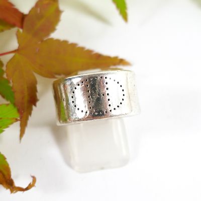 a silver ring sitting on top of a white surface
