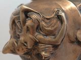 a bronze vase with a face on it on a table