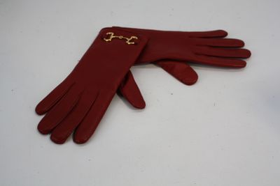 une paire de gants en cuir rouge avec une chaîne dorée au poignet