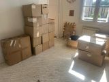 une pièce où il y a des cartons, encore et encore, par terre
