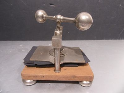 un objet métallique posé sur un socle en bois, sur une table