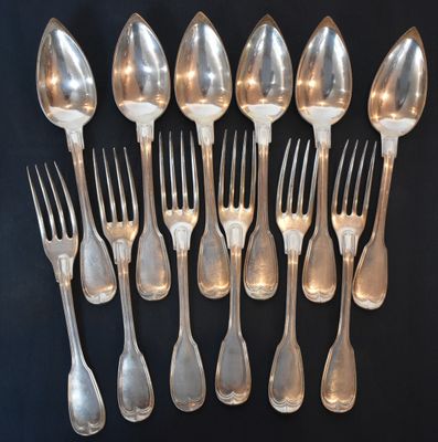 a lot of silver spoons and forks on a table