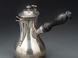 une théière en argent avec une anse sur une table