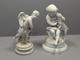 deux statues blanches représentant des anges, posées sur un socle